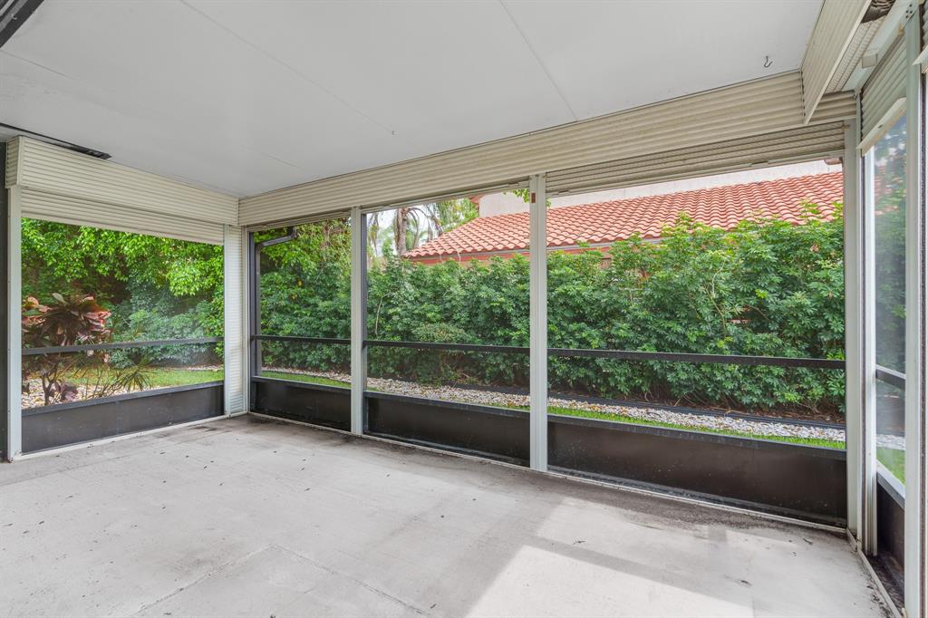 7836 Cloverfield Circle Boca Raton, FL 33433 - Photo 34 of 39 an empty room with wooden floor and outdoor view