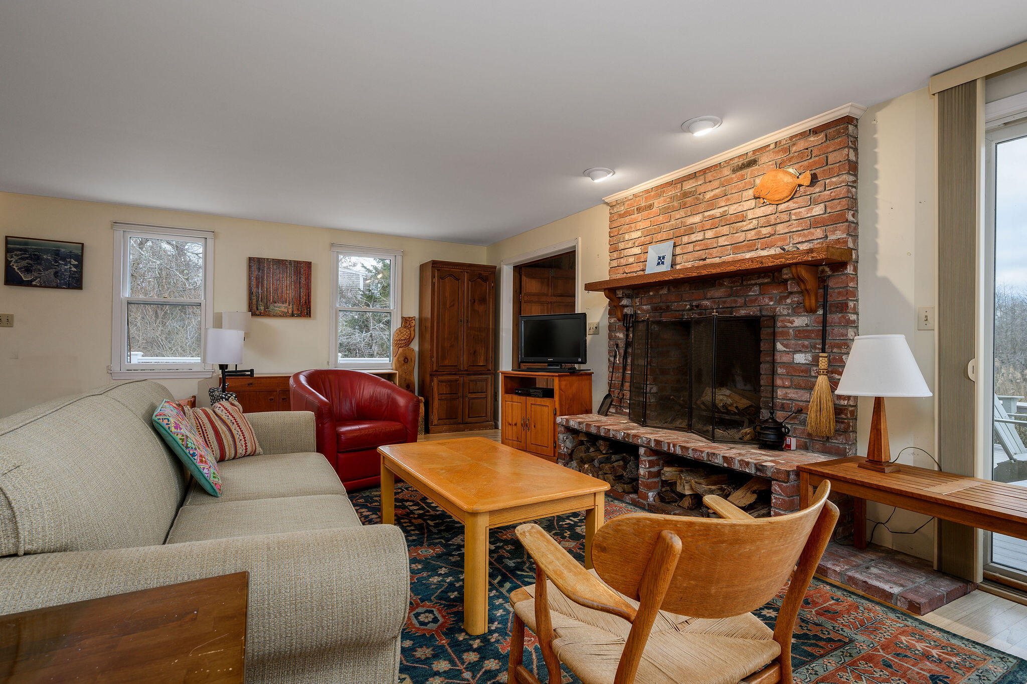 52 Captain Linnell Road Orleans, MA 02653 - Photo 11 of 45 a living room with furniture a flat screen tv and a fireplace
