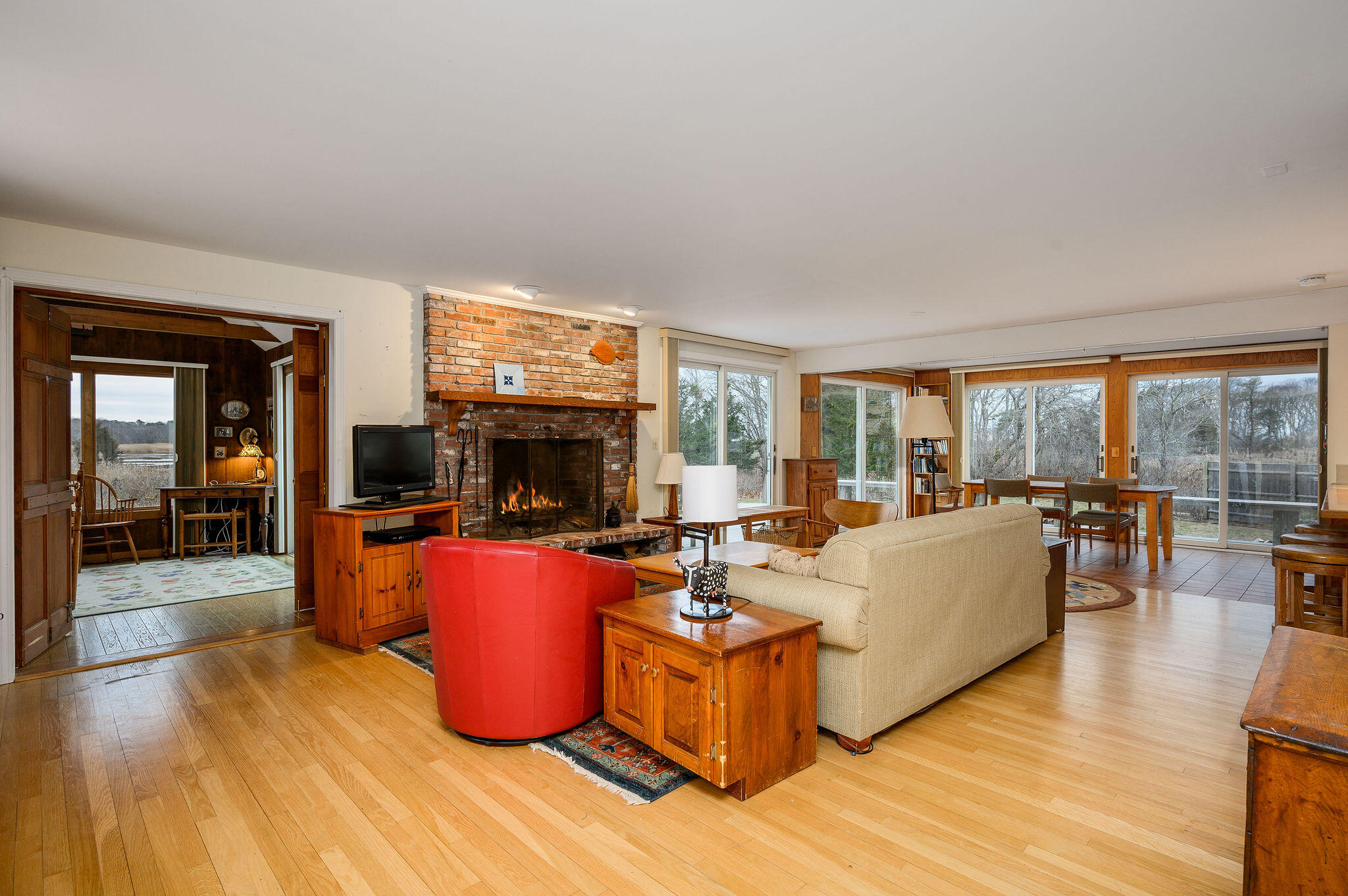 52 Captain Linnell Road Orleans, MA 02653 - Photo 9 of 45 a living room with furniture a flat screen tv and a floor to ceiling window