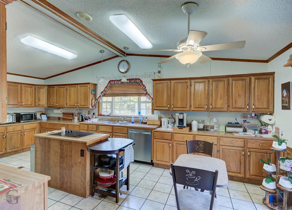 4896 Quiet Acres Road Shreveport, LA 71107 - Photo 11 of 39 a kitchen with a sink a stove cabinets and dining table