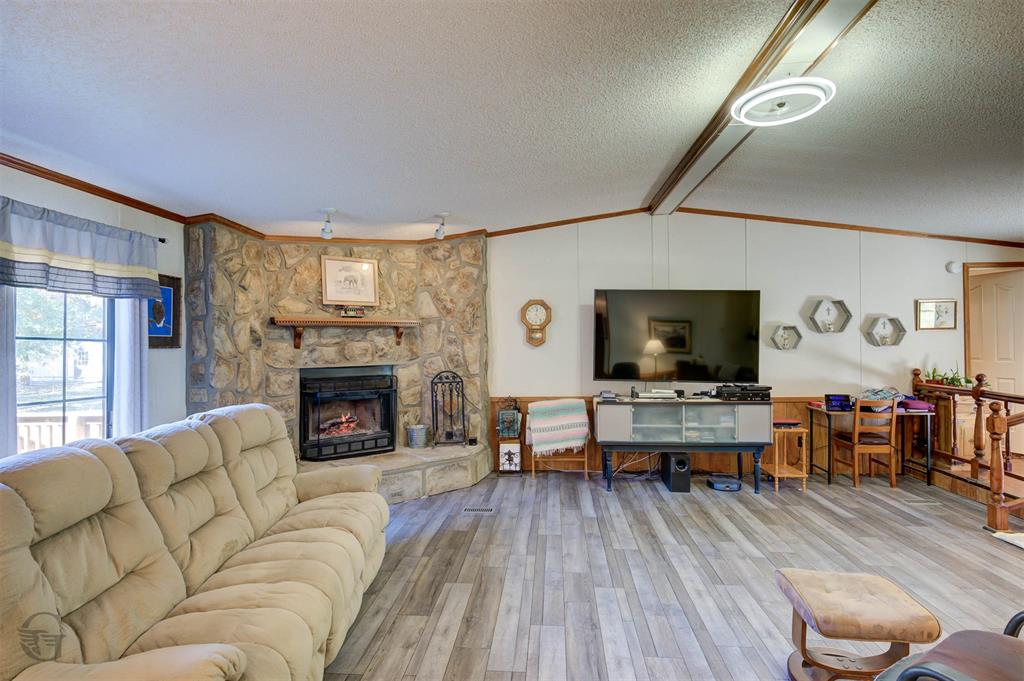 4896 Quiet Acres Road Shreveport, LA 71107 - Photo 5 of 39 a living room with furniture a flat screen tv and a fireplace