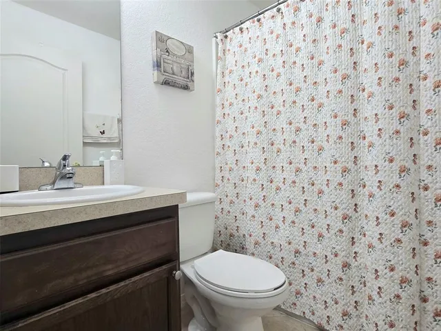 a front view of house with yard and trees in the background