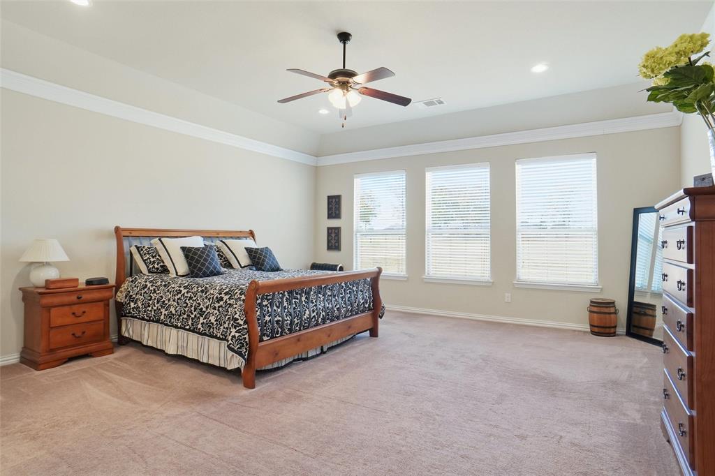 106 High Ridge Court Decatur, TX 76234 - Photo 11 of 19 a spacious bedroom with a bed and a ceiling fan
