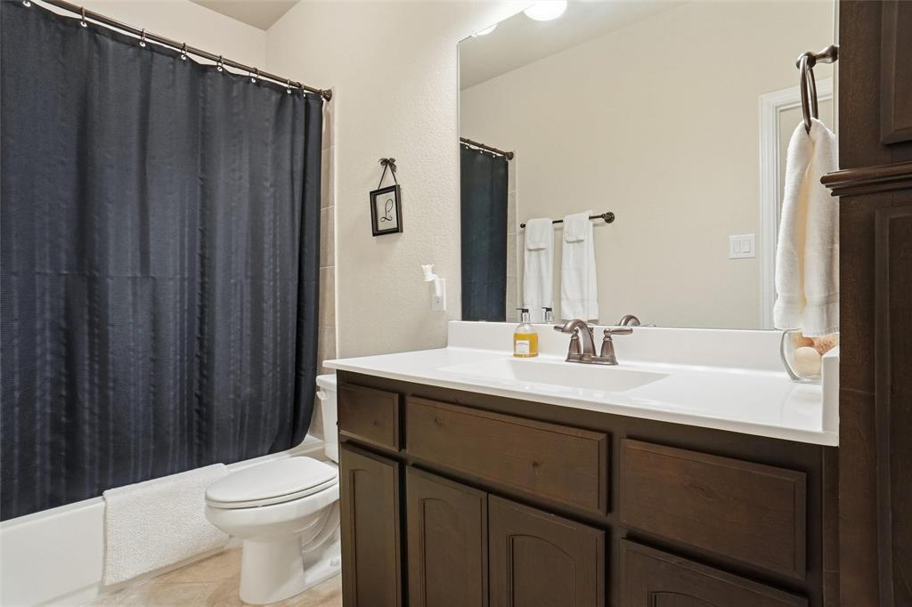 106 High Ridge Court Decatur, TX 76234 - Photo 16 of 19 a bathroom with a sink a toilet a mirror and shower curtain