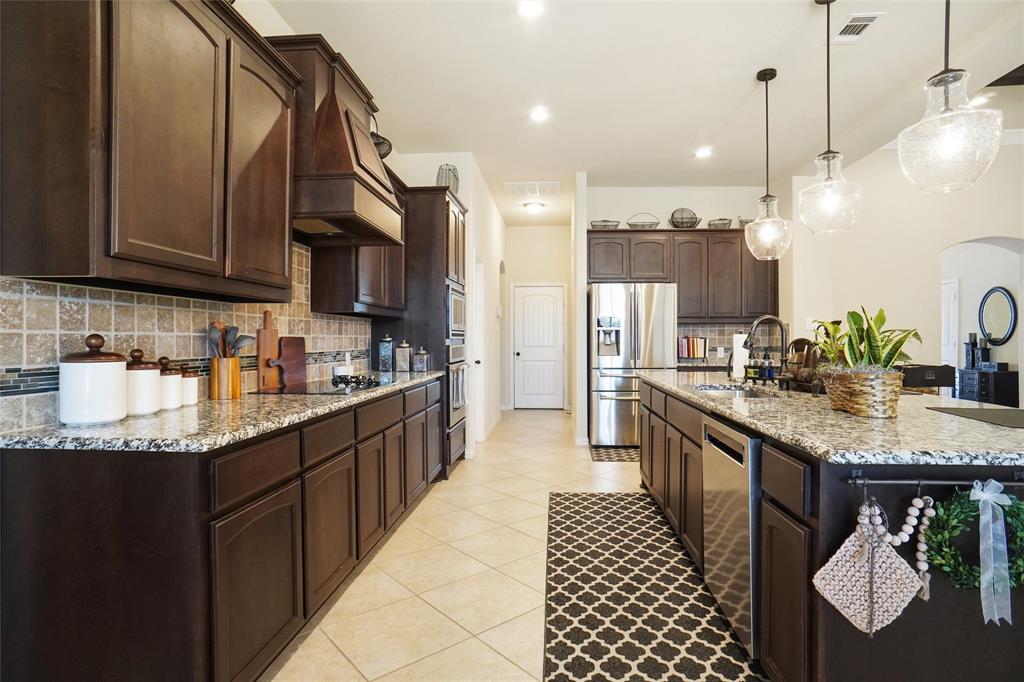 106 High Ridge Court Decatur, TX 76234 - Photo 8 of 19 a kitchen with granite countertop a sink a counter top space appliances and cabinets