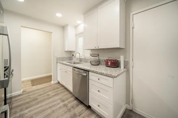 a kitchen with granite countertop a sink stainless steel appliances and cabinets