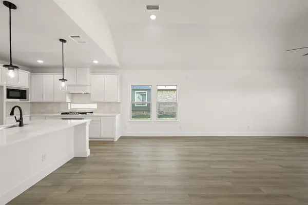 a kitchen with stainless steel appliances granite countertop a sink a stove and a refrigerator
