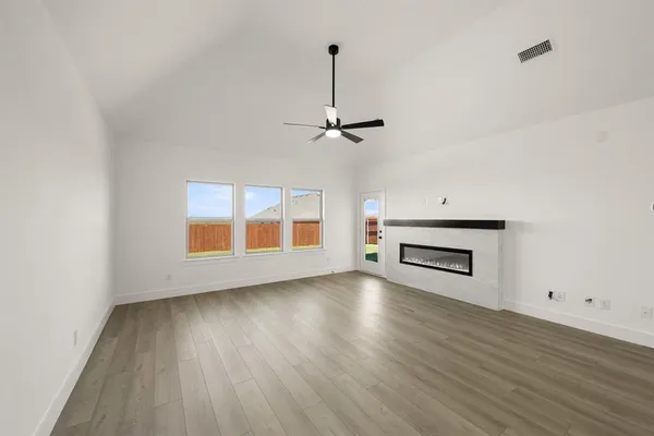 a view of a livingroom with wooden floor and a ceiling fan