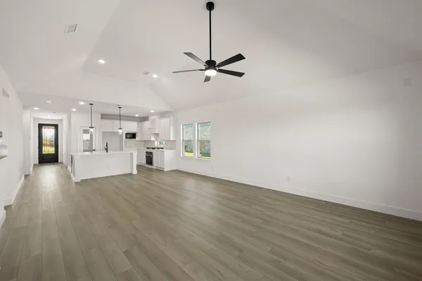a view of a kitchen with a sink dishwasher a refrigerator with wooden floors