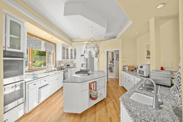 a kitchen with stainless steel appliances kitchen island granite countertop a refrigerator and a stove top oven