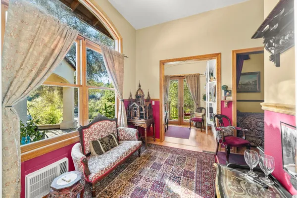 a living room with furniture a flat screen tv and a floor to ceiling window
