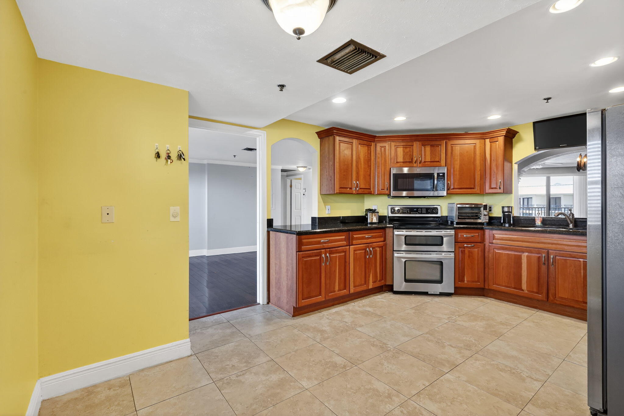 1035 South Federal Highway, Unit PH3 39 Delray Beach, FL 33483 - Photo 19 of 44 a large kitchen with stainless steel appliances granite countertop a stove refrigerator and a microwave oven