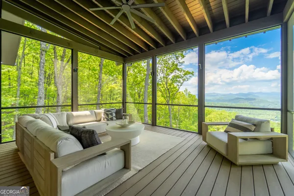 a living room with furniture and a large window with garden view