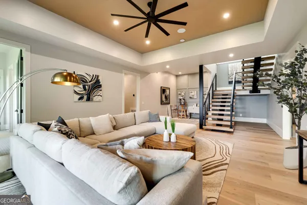 a spacious bedroom with a bed painting on wall and a large window