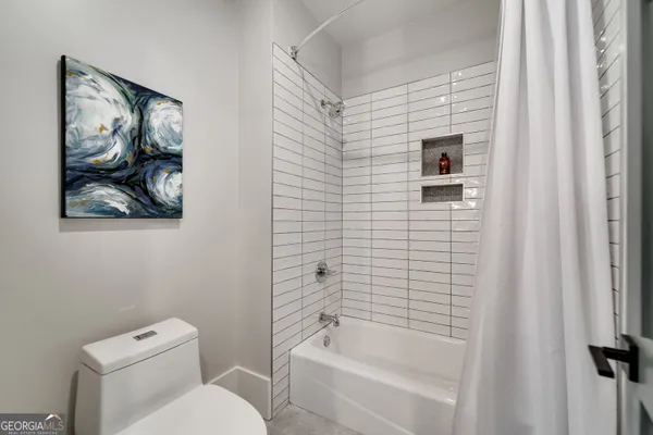 a bathroom with a sink a toilet a mirror and shower