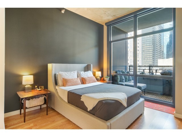 235 West Van Buren Street, Unit 1616 Chicago, IL 60607 - Photo 8 of 16 a bedroom with a bed window and a table