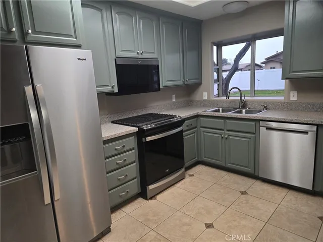 a kitchen with stainless steel appliances a refrigerator sink and cabinets