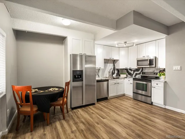 a kitchen with stainless steel appliances granite countertop a stove a refrigerator and a microwave