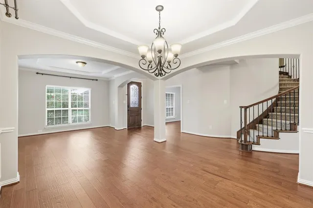a view of a room with wooden flooring and lots of windows