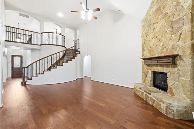 a view of an empty room with wooden floor a fireplace