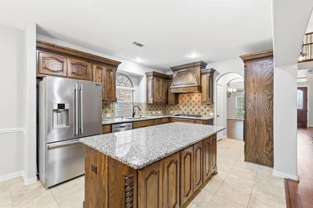 a kitchen with stainless steel appliances granite countertop a refrigerator and a sink