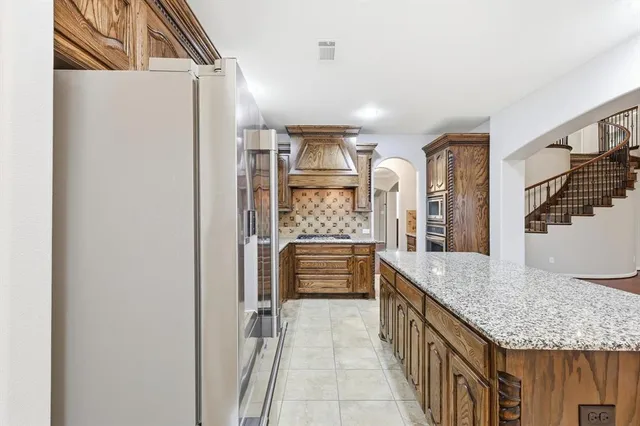 a bathroom with a granite countertop sink a mirror and a shower