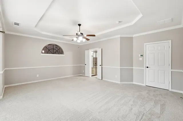a view of an empty room with a chandelier fan