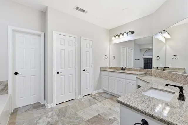a spacious bathroom with a granite countertop sink and a mirror