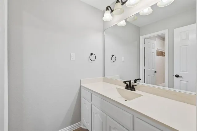 a bathroom with a sink vanity and a mirror