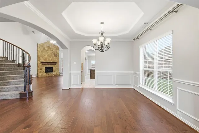 a view of a room with wooden floor fireplace and windows