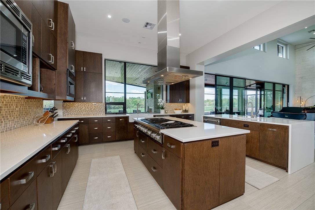 3320 Sycamore Trail Bryan, TX 77807 - Photo 15 of 48 Kitchen featuring a center island, island exhaust hood, decorative backsplash, and stainless steel appliances