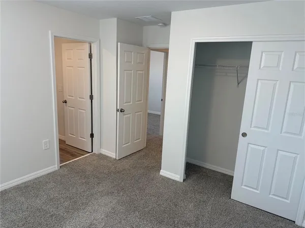 an empty room with closet and a bathroom