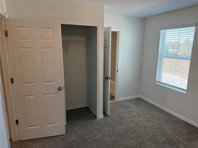 an empty room with windows and closet
