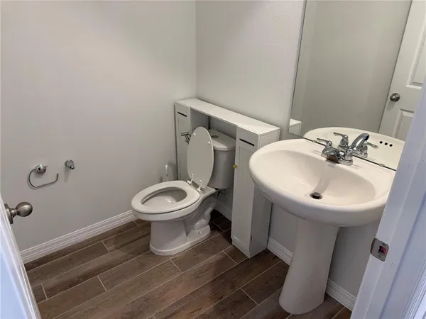 a bathroom with a sink toilet and a mirror