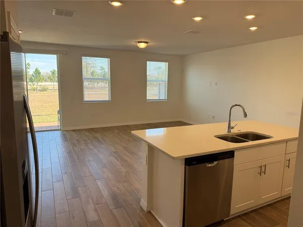 a kitchen with a sink and wooden floor