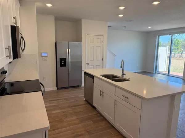 a kitchen with stainless steel appliances a sink stove and refrigerator
