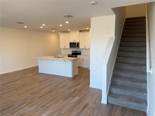 a view of kitchen with wooden floor and electronic appliances