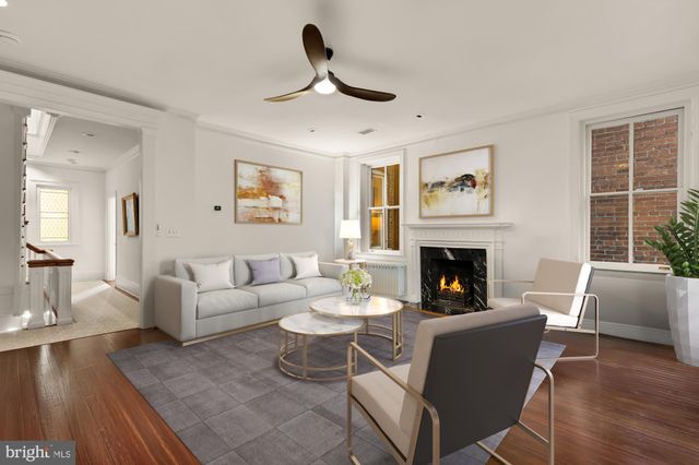 a living room with furniture a fireplace and a large window