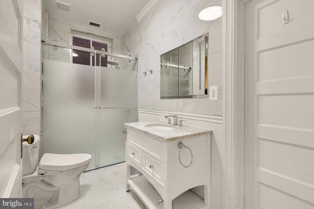 a bathroom with a toilet sink vanity and mirror