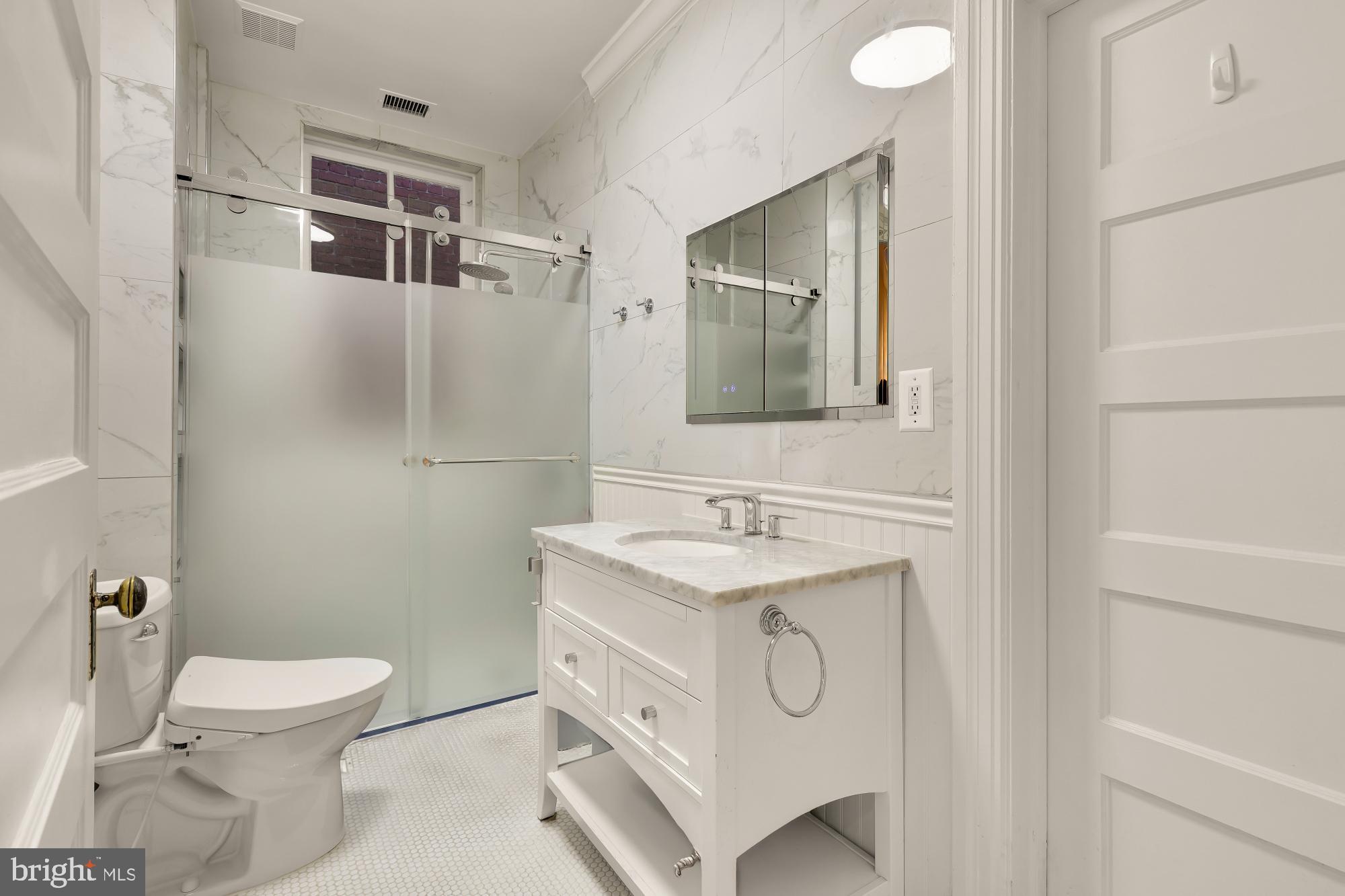 2137 R Street Northwest Washington, DC 20008 - Photo 34 of 41 a bathroom with a toilet sink vanity and mirror