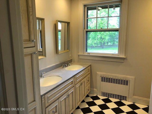 5 Brookridge Drive Greenwich, CT 06830 - Photo 17 of 17 a bathroom with a sink a mirror a bathtub and next to a window