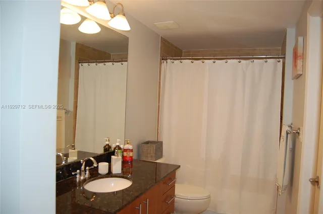 a bathroom with a sink vanity mirror and toilet