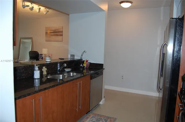 a kitchen with stainless steel appliances granite countertop a refrigerator and a stove