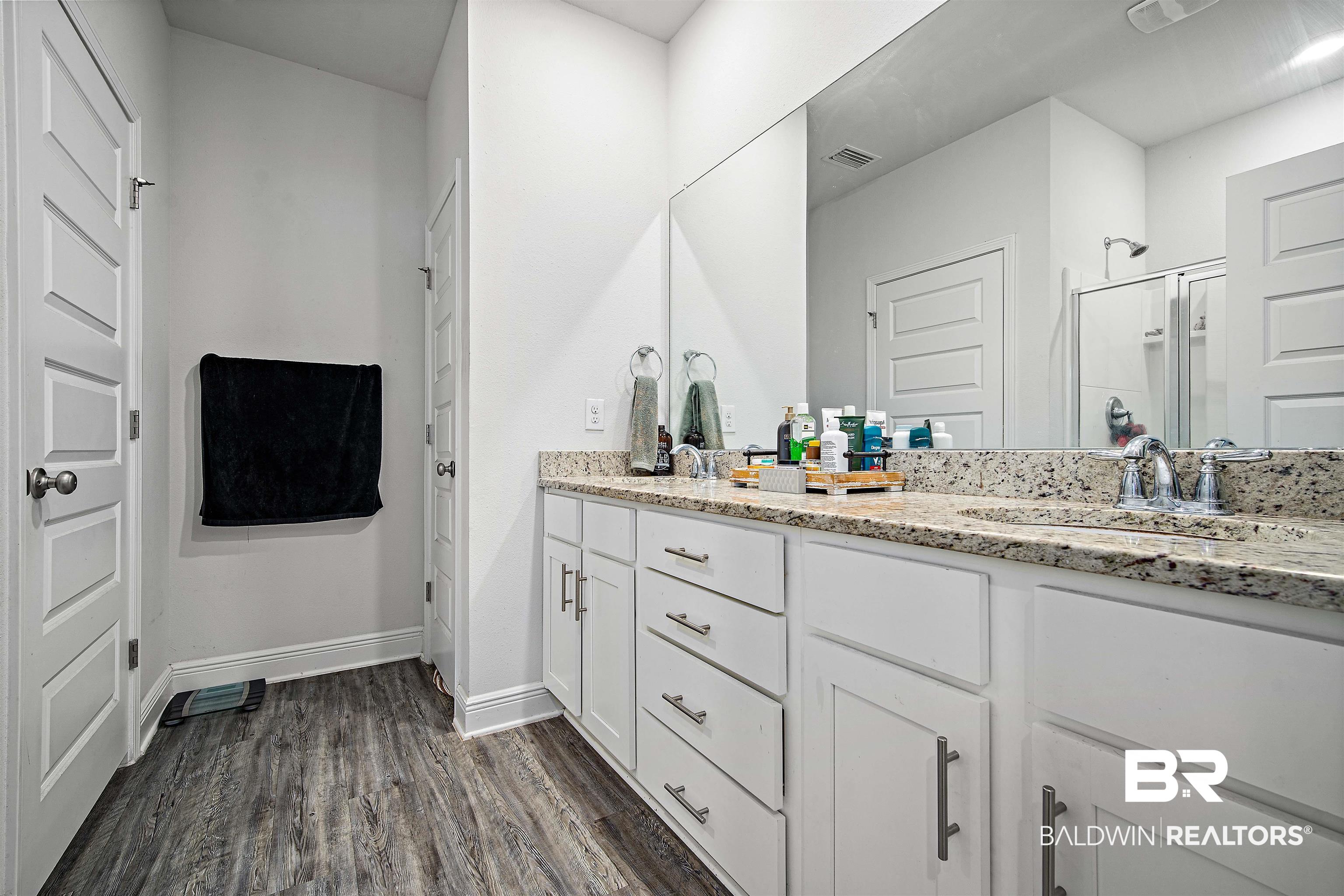 24341 Alydar Loop Daphne, AL 36526 - Photo 18 of 45 Bathroom featuring a stall shower, double vanity, wood finished floors, and baseboards