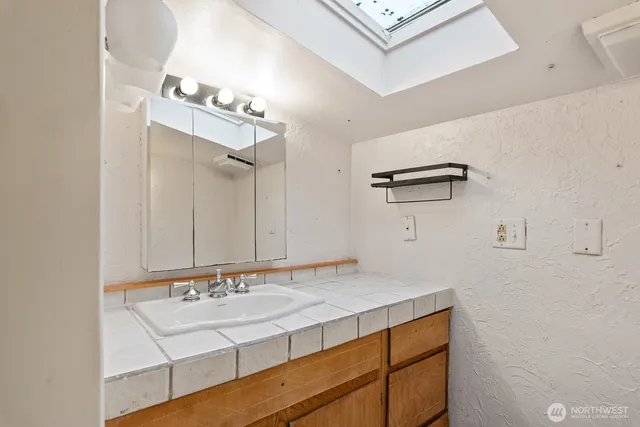 a bathroom with a sink vanity and mirror