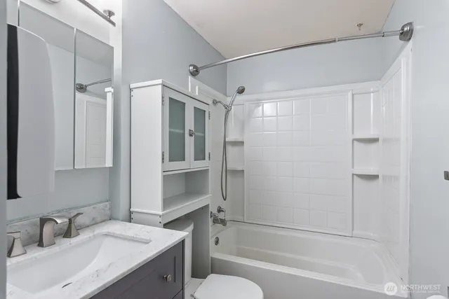 a bathroom with a granite countertop sink toilet and shower