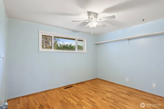 a view of an empty room with a chandelier fan