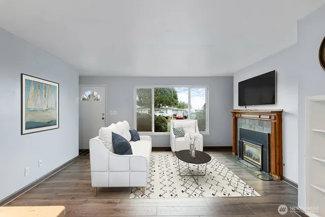 a living room with furniture a flat screen tv and a fireplace