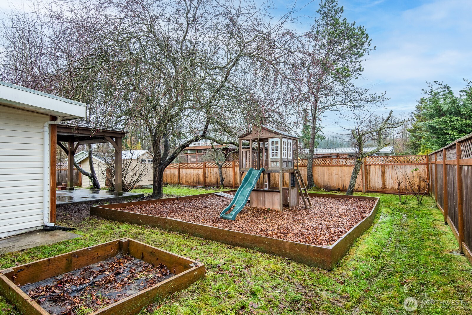 1705 36th Street Anacortes, WA 98221 - Photo 31 of 39 a view of a backyard with a small cabin and wooden fence