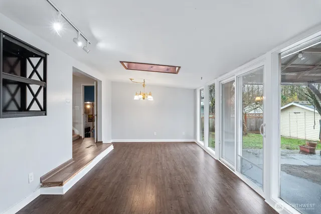 a view of a big room with wooden floor and windows